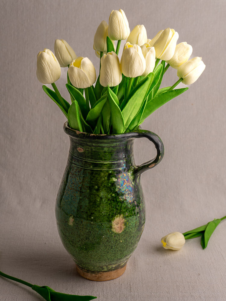 19th-century French green glazed terracotta pitcher with handle, textured surface, and unglazed spots.