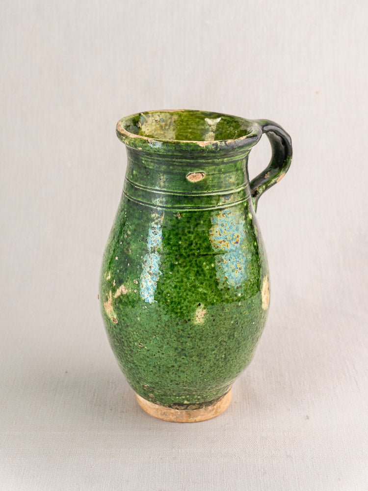 19th-century French green glazed terracotta pitcher with single handle and rustic Provence texture.