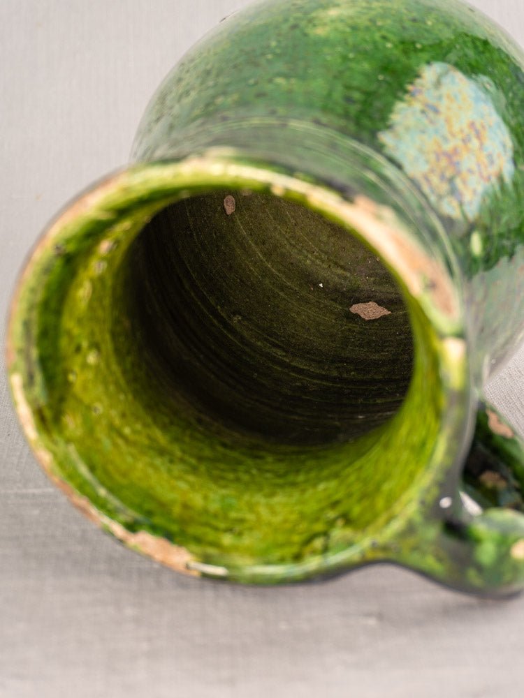 Antique French green glazed terracotta pitcher with worn rim and visible interior, Southern France.