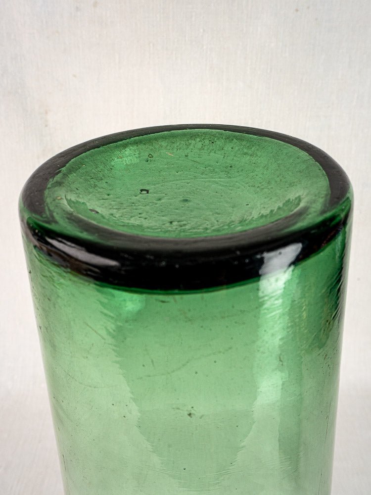 Antique French hand-blown green preserves bottle base with thick, irregular glass and circular rim.