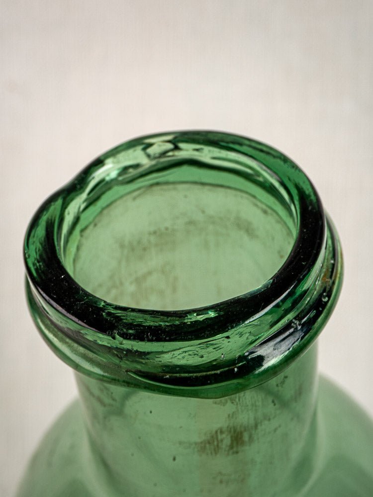 Antique French hand-blown green glass preserves bottle, wavy texture and bubbles, circa 1900.