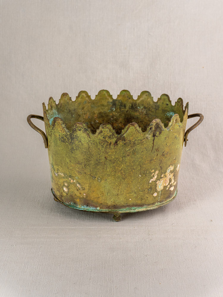 Antique French brass wine cooler with scalloped edges, side handles, and green painted patina.