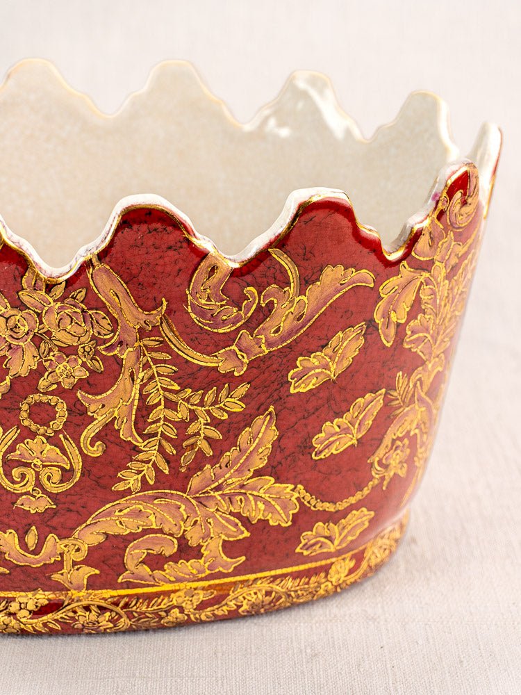 Late 19th-century Terre de Fer ceramic wine cooler with scalloped rim, red glaze, and gold floral motifs against a light background.