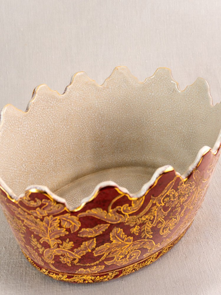 Antique French Terre de Fer wine cooler with scalloped rim, red and gold floral motifs, cream crackled interior.