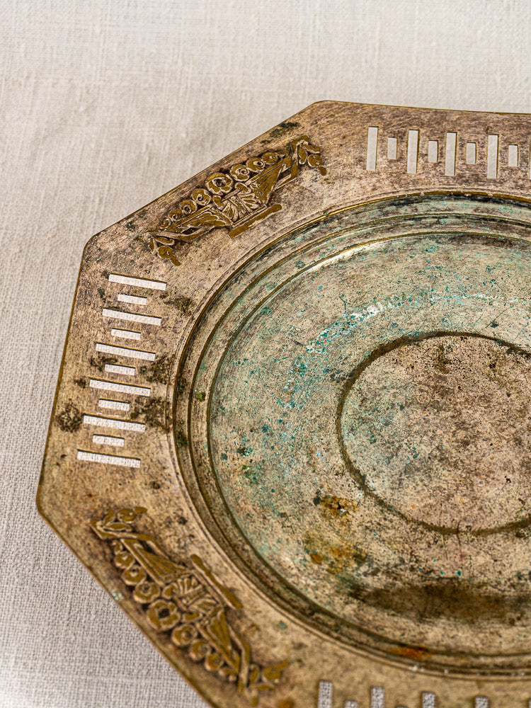 Art Deco French silver plate tazza with octagonal foot and engraved floral baskets on light fabric background.