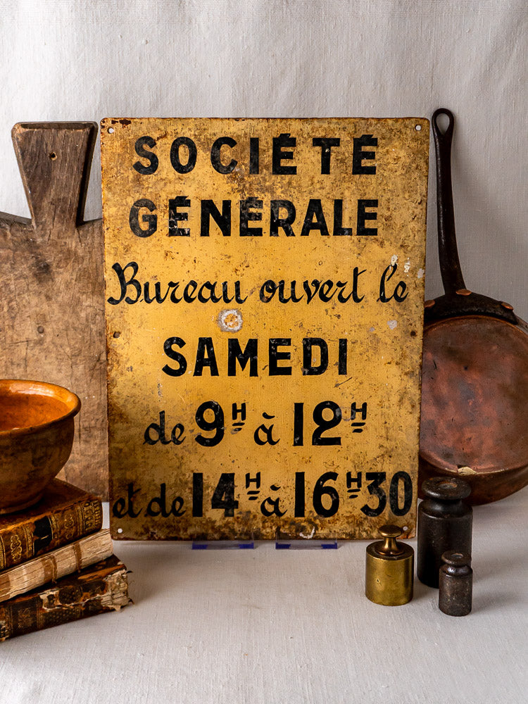 Antique French Société Générale hand-painted steel bank sign with vintage kitchenware, books, and weights.
