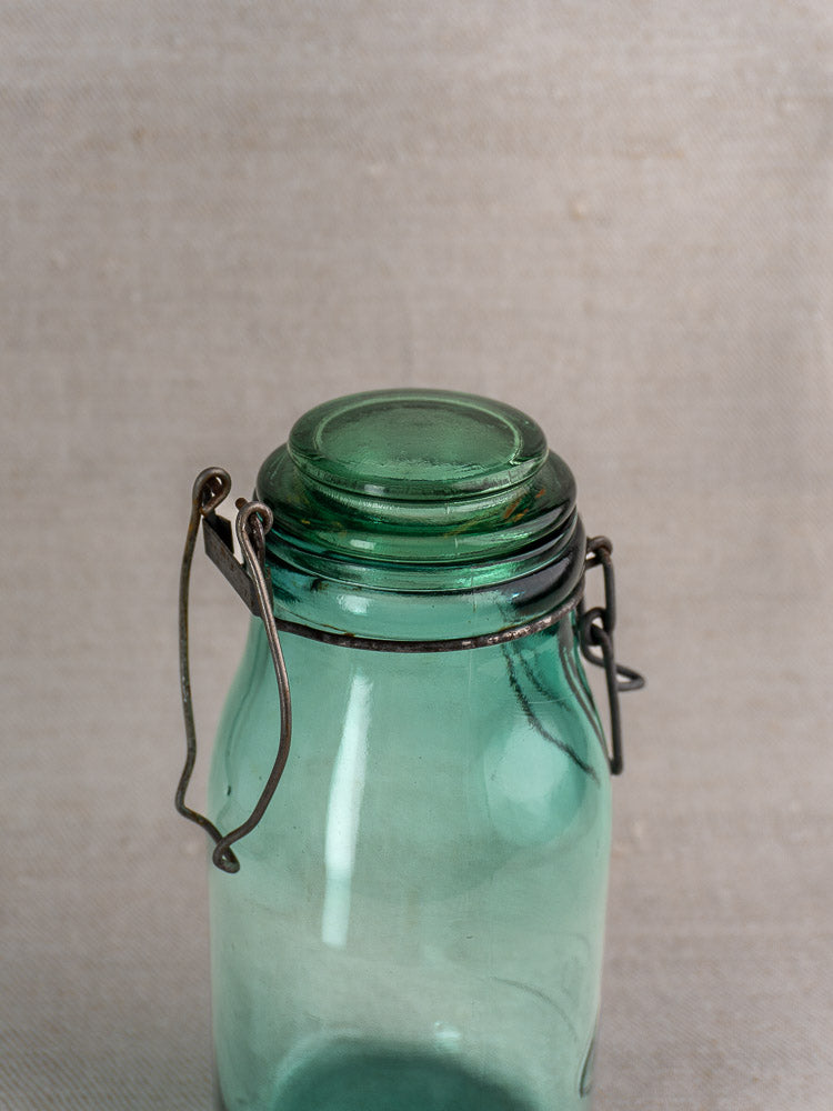 Set of three antique French Solidor & Durfor green glass preserve jars with metal wire clasps and lids on neutral background.
