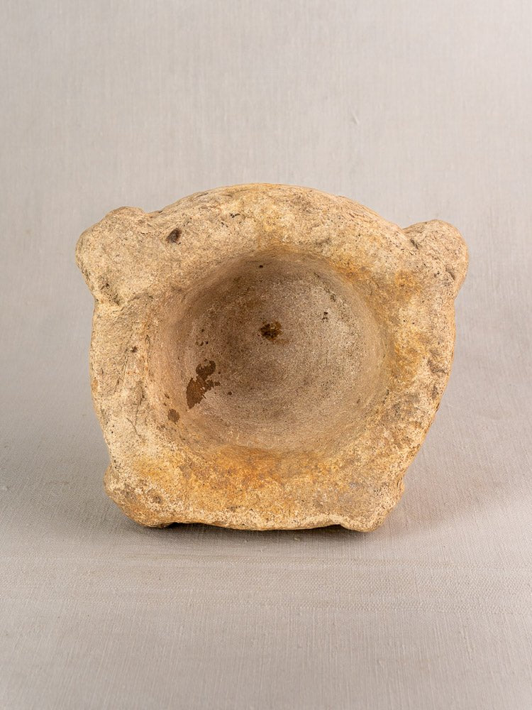 Antique French limestone mortar and pestle with thick sides, hand-carved details, and rustic patina on light gray background.