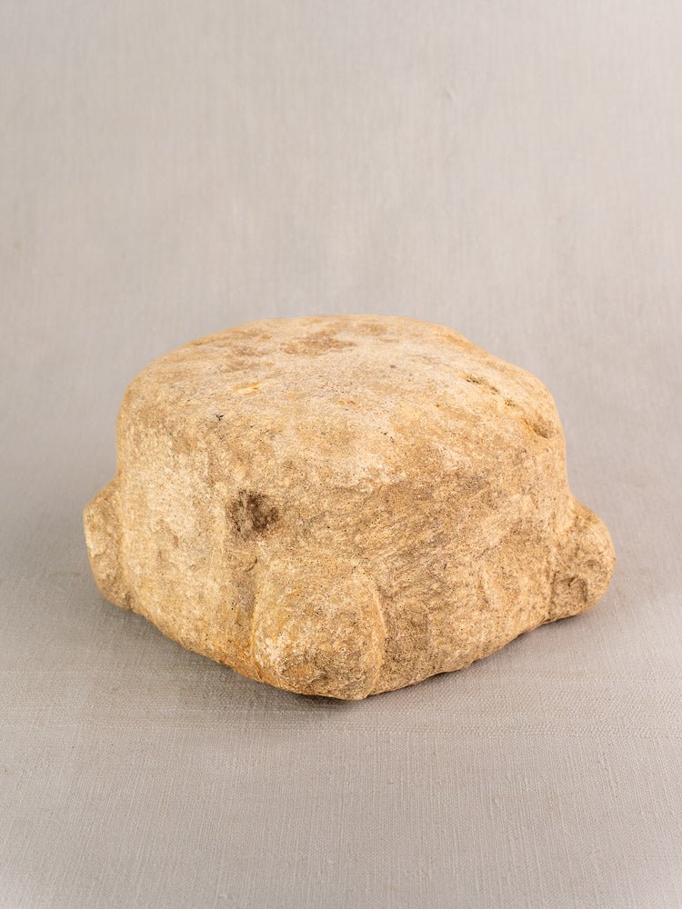 19th-century French stone mortar and pestle with textured, worn surface, four rounded corners, on light gray background.