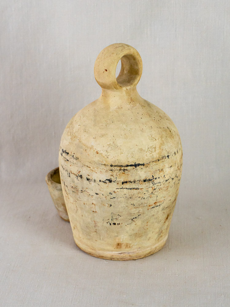 Antique French stoneware bird waterer in beige ceramic with circular handle and textured finish.