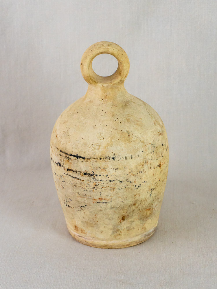 Antique French stoneware bird waterer with rounded body, narrow neck, loop handle, and textured beige clay.