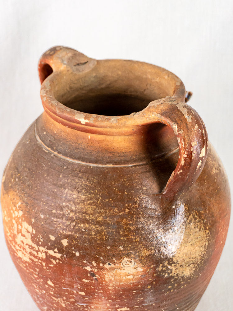 Antique French stoneware pot à huile with ochre glaze, two handles, weathered textured grès surface.