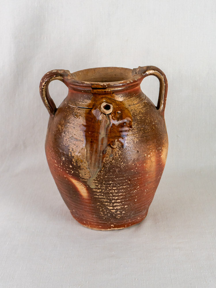 Antique French grès stoneware oil jug with ochre glaze, two handles, rustic dripping.