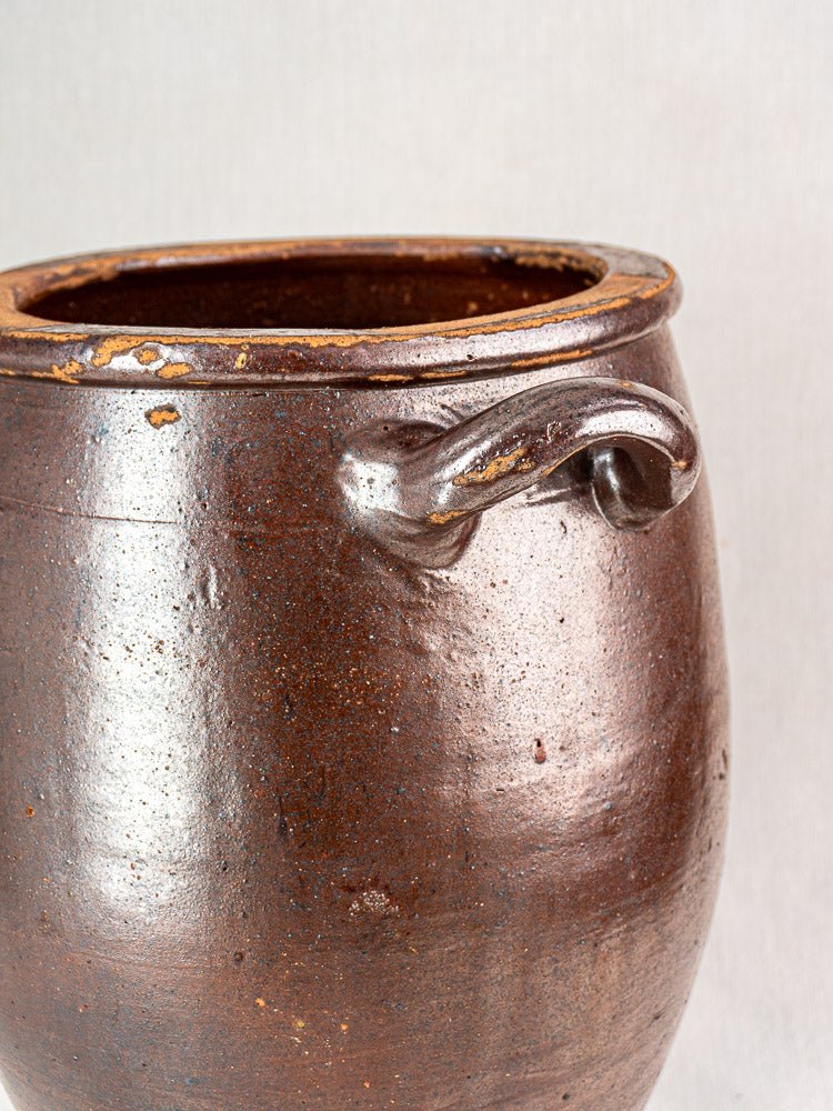 Antique French stoneware storage jar with single curved handle and glossy textured finish.