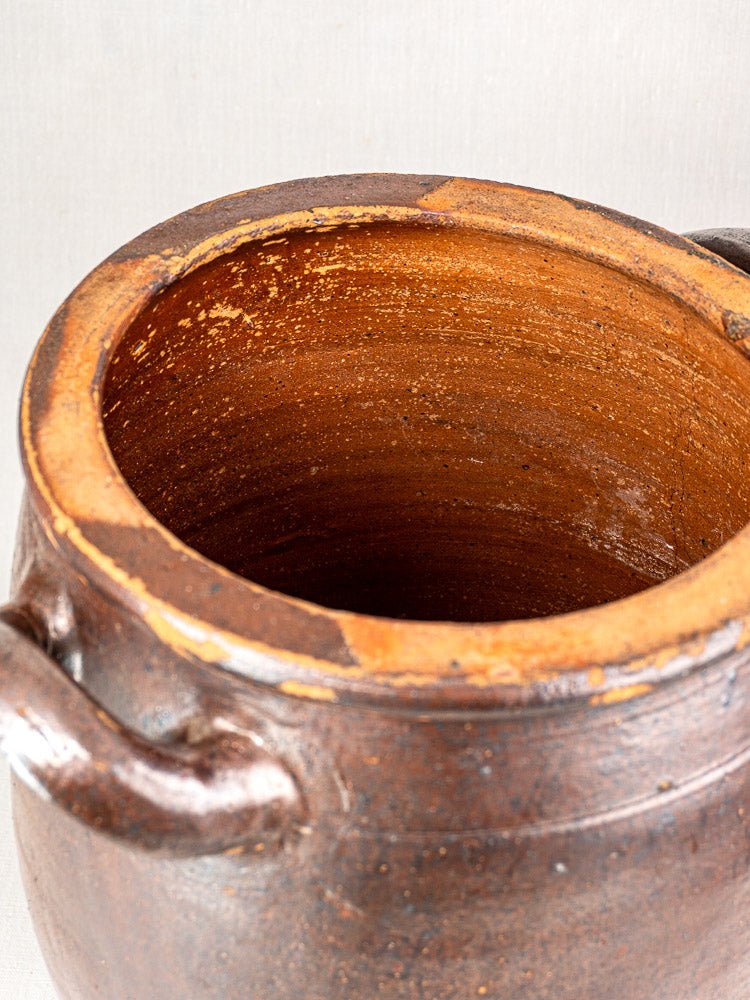 Antique French storage jar in salt glazed stoneware with brown textured exterior and twin handles.