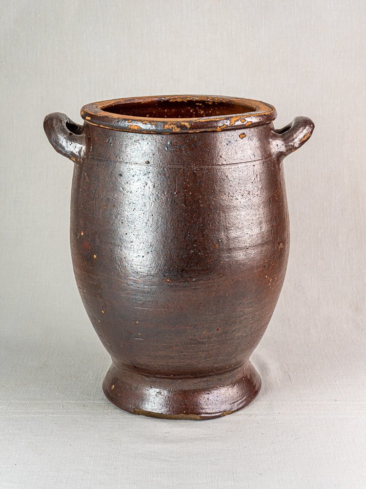 Antique French salt-glazed stoneware Pot à Graisse with brown finish and side handles on neutral background.