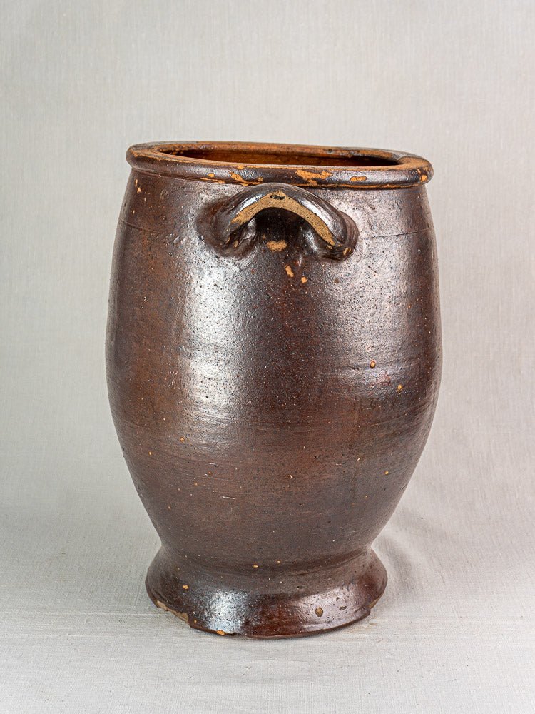 Antique French salt glazed stoneware storage jar with rounded body, narrow base, and looped handle.