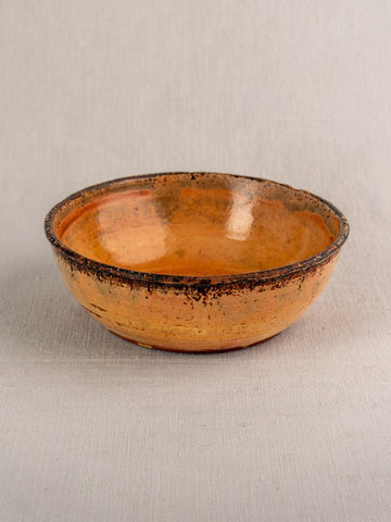 Antique French yellow glazed earthenware Tian baking dish, late 19th century, on light gray fabric.