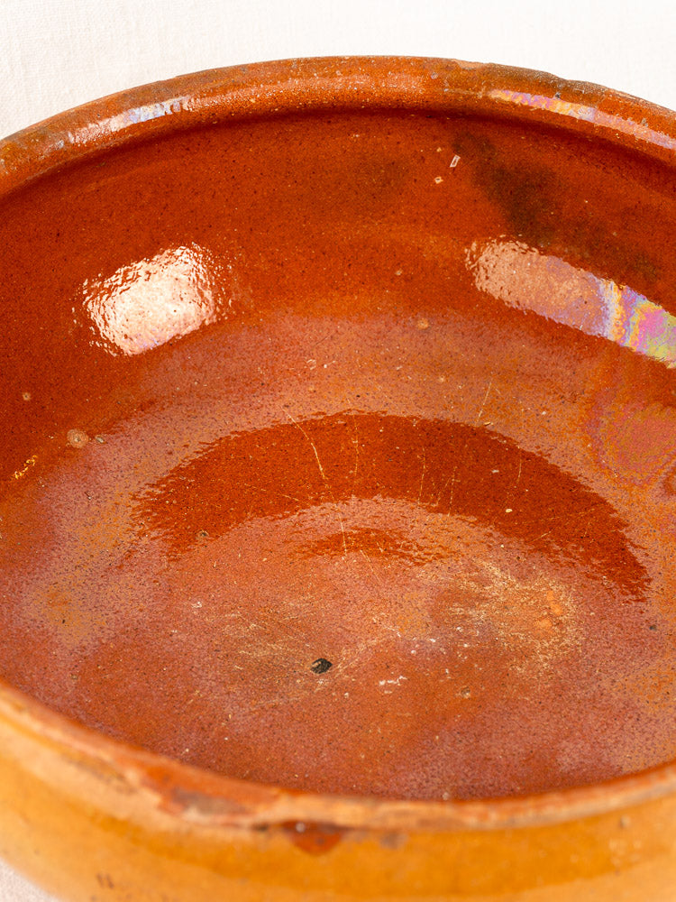 Antique French Vallauris glazed terracotta poêlon with rustic round shape and reddish-brown sheen, early 20th century.