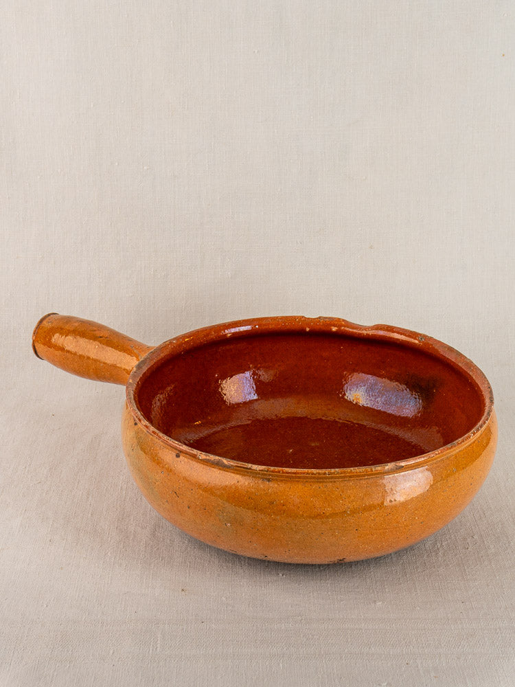Antique French Vallauris poêlon, early 20th century glazed terracotta, round shallow brown form, single left handle.