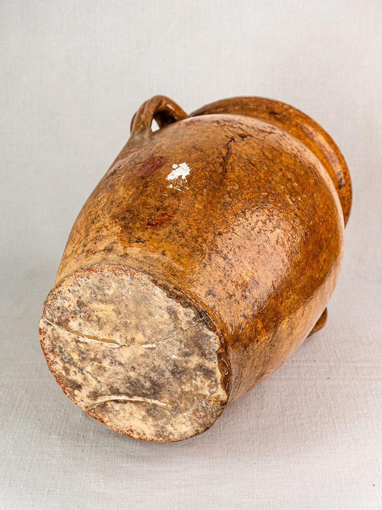 19th-century French terracotta storage jar with rustic brown clay and yellow glazed interior.