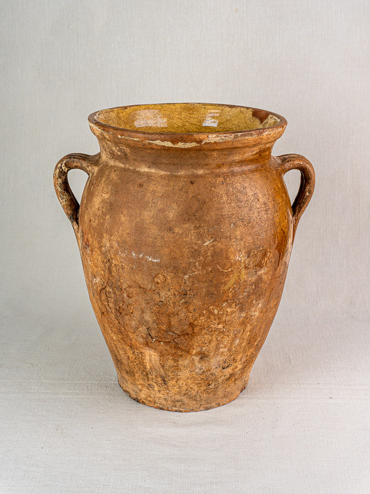 19th-century French terracotta storage jar with yellow glazed interior and two side handles.
