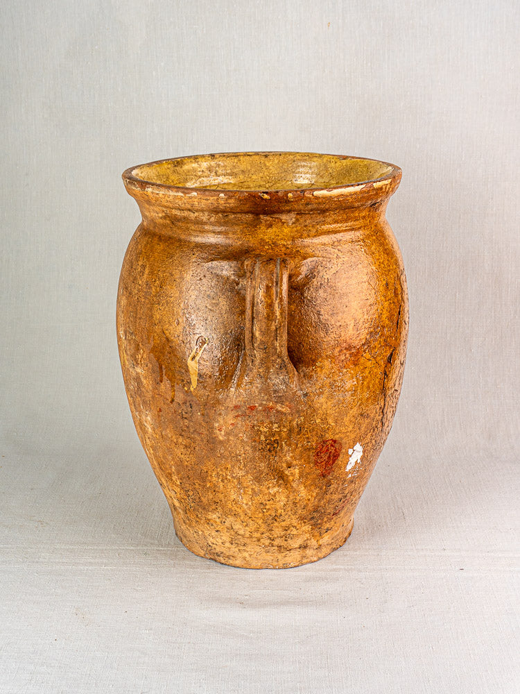 Antique French terracotta storage jar with rustic brown ceramic, flared rim, and yellow glazed interior.