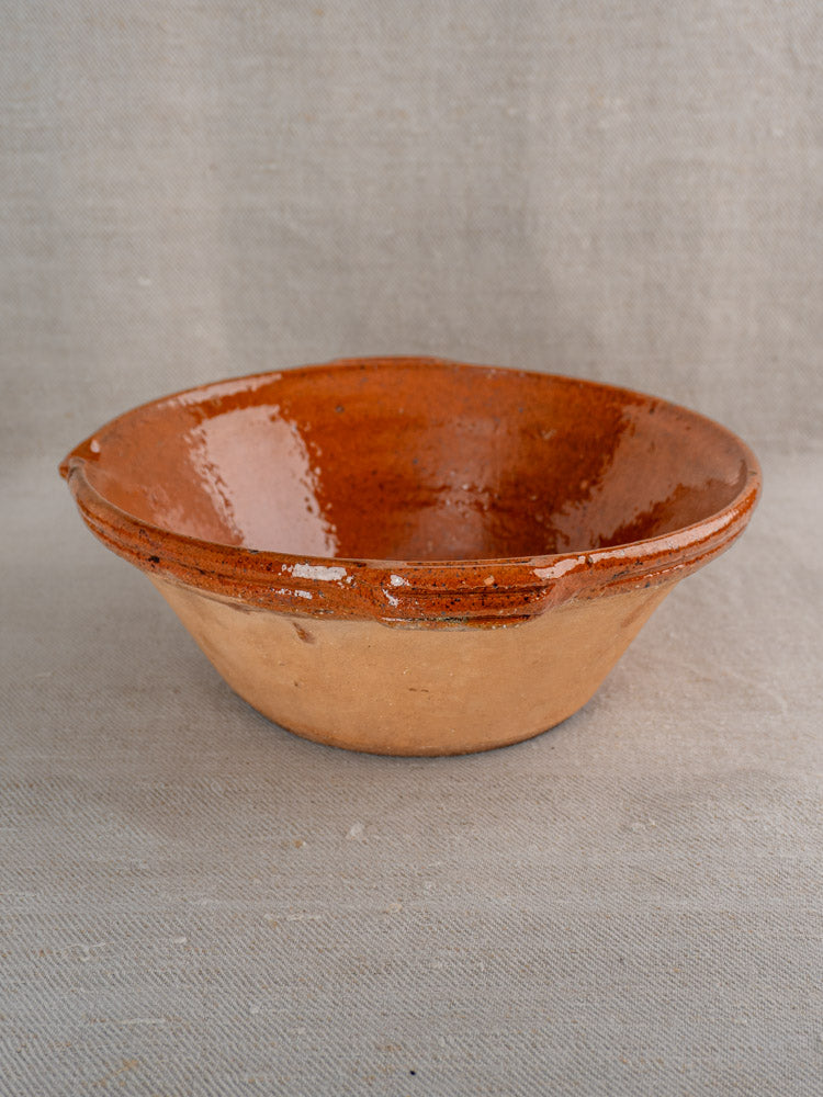 Pair of antique French Languedoc tian bowls with brown glazed interiors and matte exteriors on beige fabric.