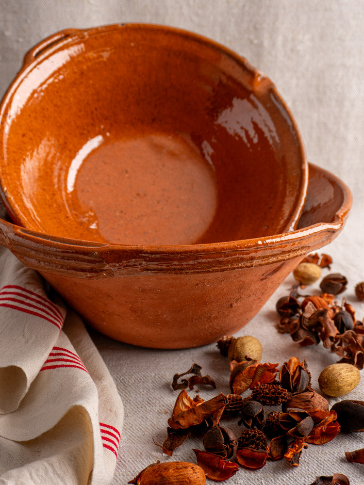 Antique French Languedoc Tian Bowls in glazed earthenware, stacked near a white napkin and dried spices.