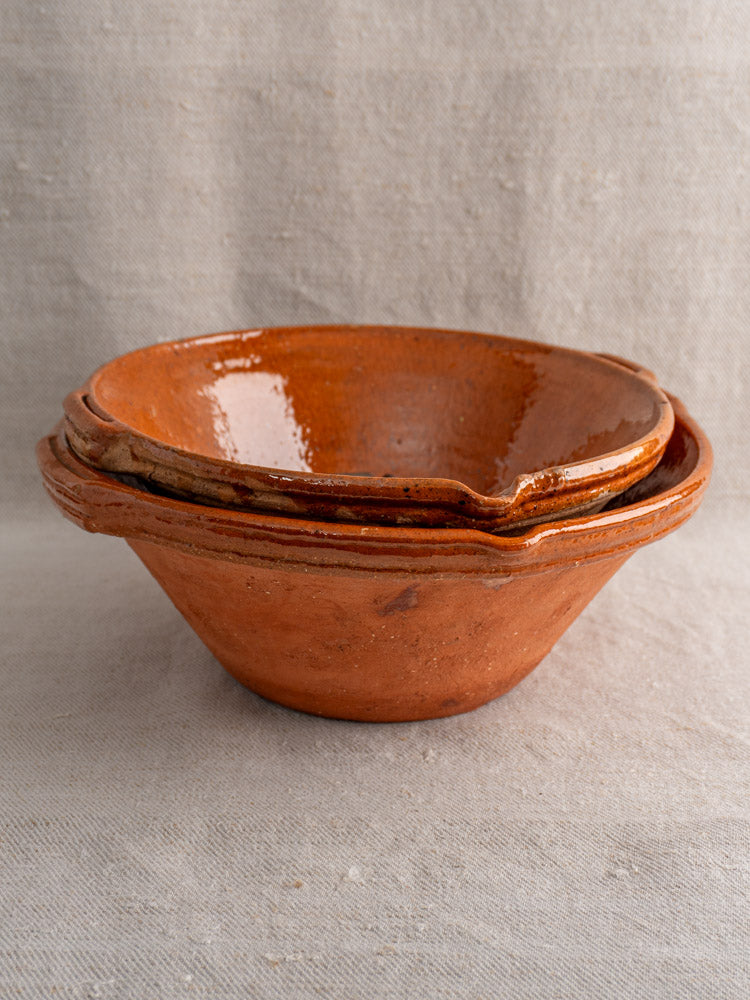 Pair of antique French Languedoc tian bowls in glazed earthenware on textured fabric background.