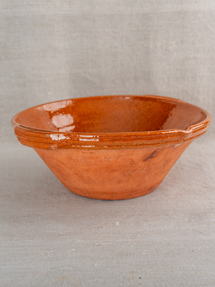 Pair of antique French Languedoc Tian bowls in glazed earthenware on a light beige fabric background.