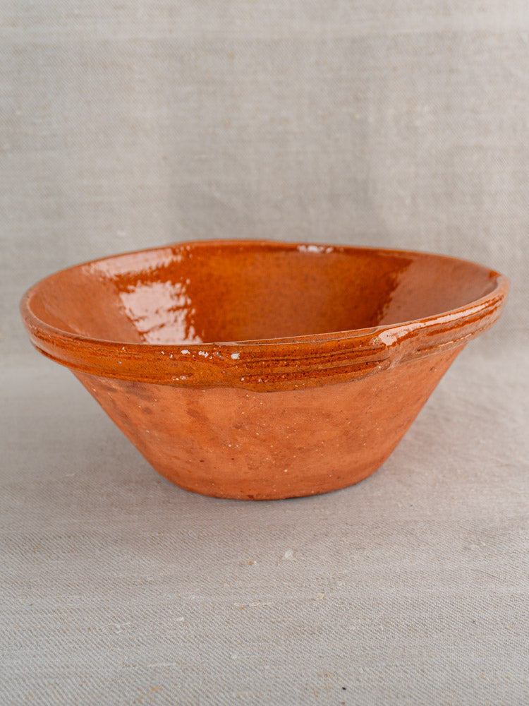Pair of antique French Languedoc tian bowls in reddish-brown glazed earthenware on textured fabric.