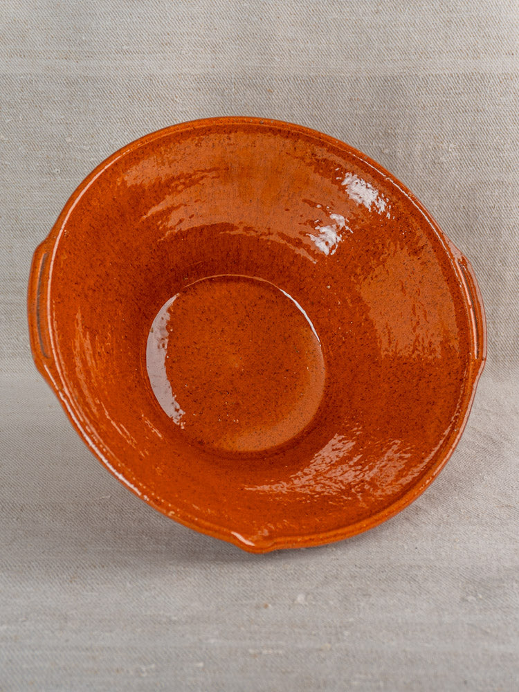 Pair of antique French Languedoc Tian glazed earthenware bowls with reddish-brown finish on neutral fabric.