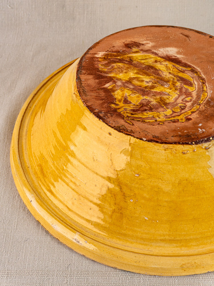 Antique French yellow glazed terracotta Tian bowl, upside down, showing unglazed base and worn glaze.