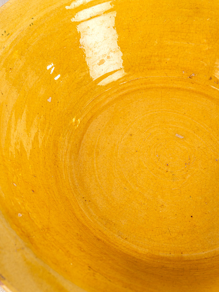 Antique French yellow glazed terracotta Tian bowl with glossy ochre finish and circular interior patterns.