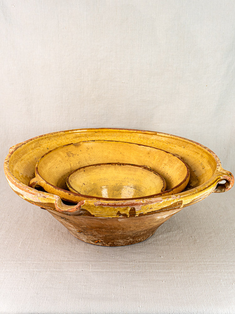 Antique Provençal yellow terracotta tian bowls, nesting set of three, with rustic glaze and patina.