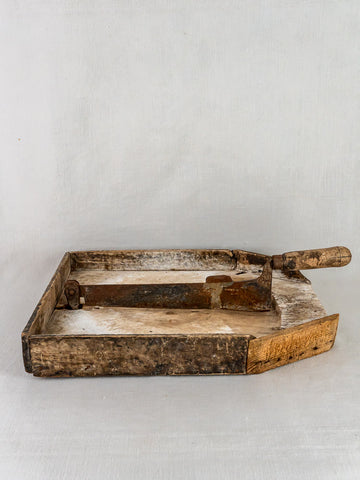 Antique French Coupe-Tabac tobacco cutter with wood and iron, metal blade and handle on light background.