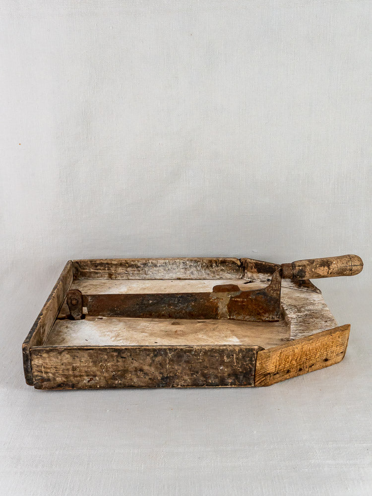Antique French Coupe-Tabac tobacco cutter with wood and iron, metal blade and handle on light background.