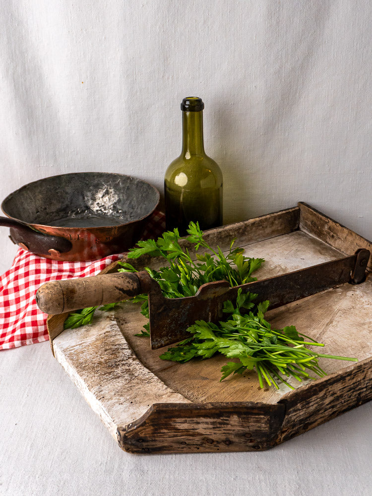 French antique wood and iron tobacco cutter with herb chopper on rustic board, 19th-century kitchen decor.