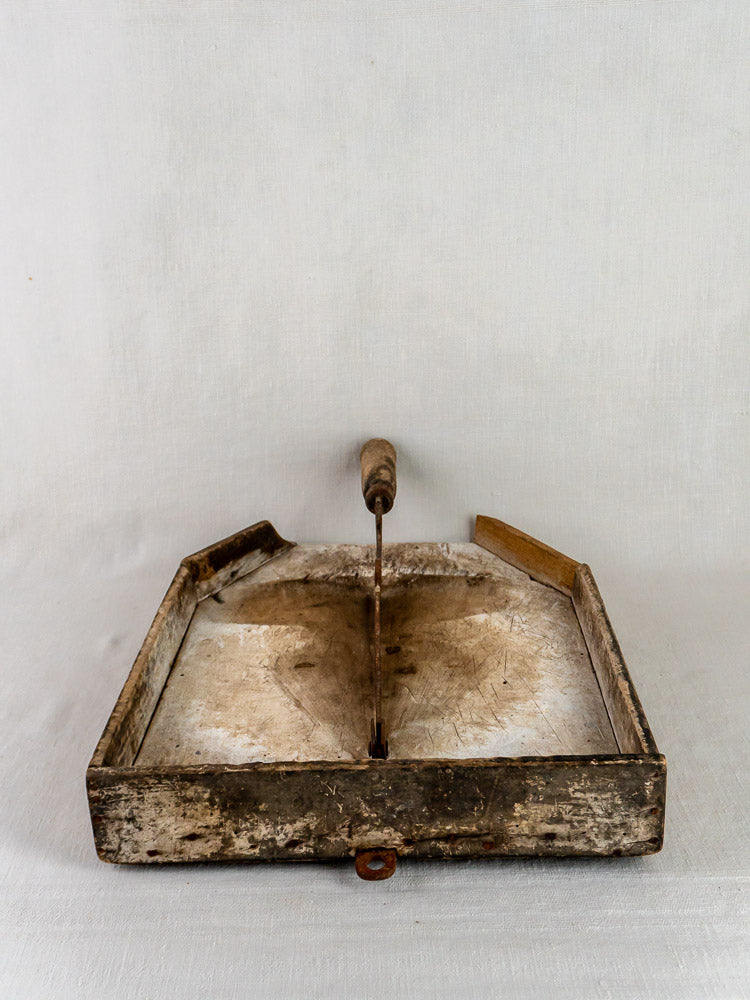 Antique French wood and iron tobacco cutter with worn handle displayed on a rectangular base.