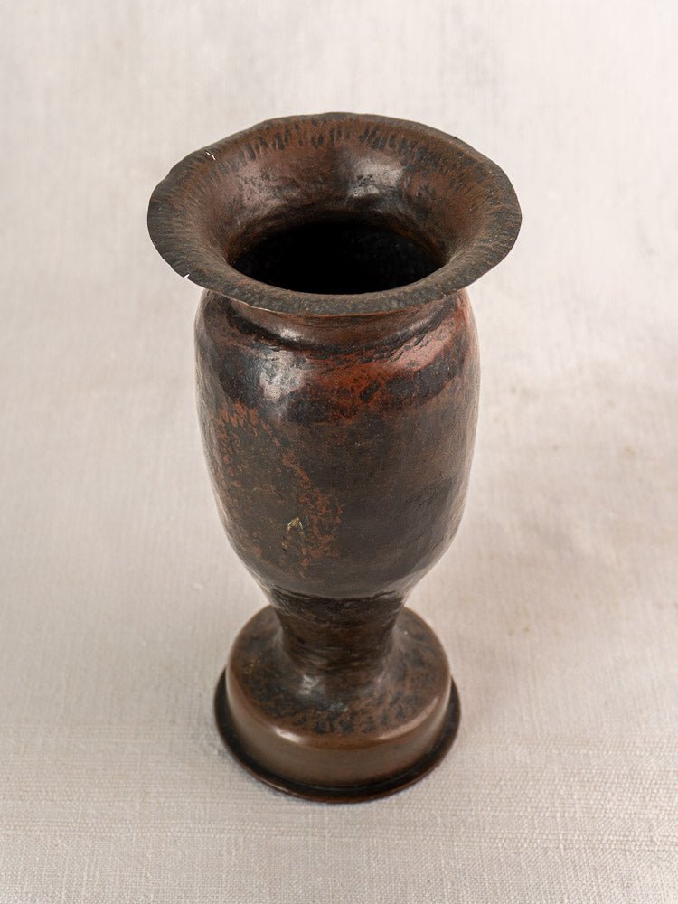 Antique French Trench Art vase, WWI 1917 shell casing, martelé finish, flared rim, textured background.