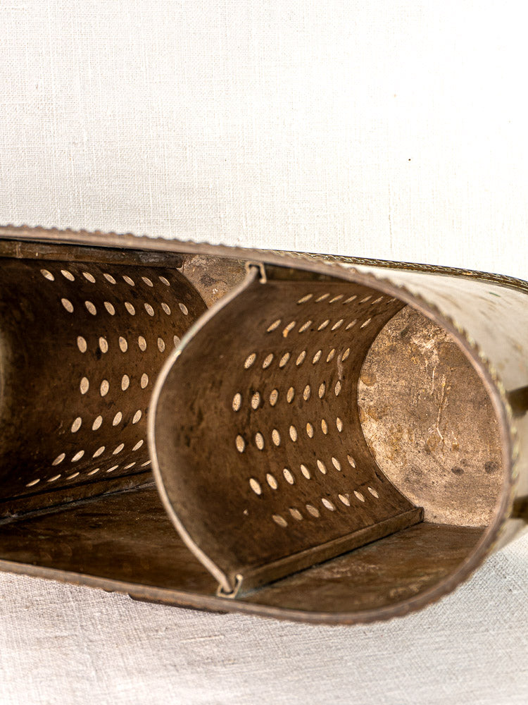 Antique French brass double champagne cooler with divided interior, oval shape, on white textured background.
