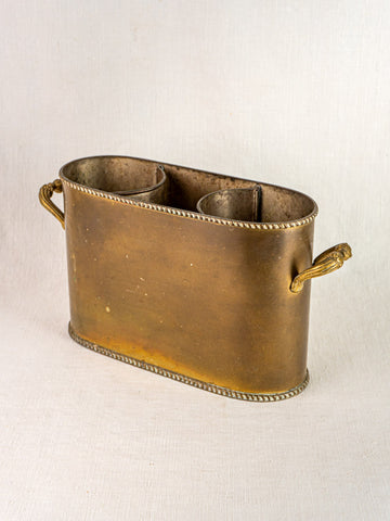 Antique French brass double champagne cooler with oval shape, rope trim, side handles, and three compartments on neutral fabric.