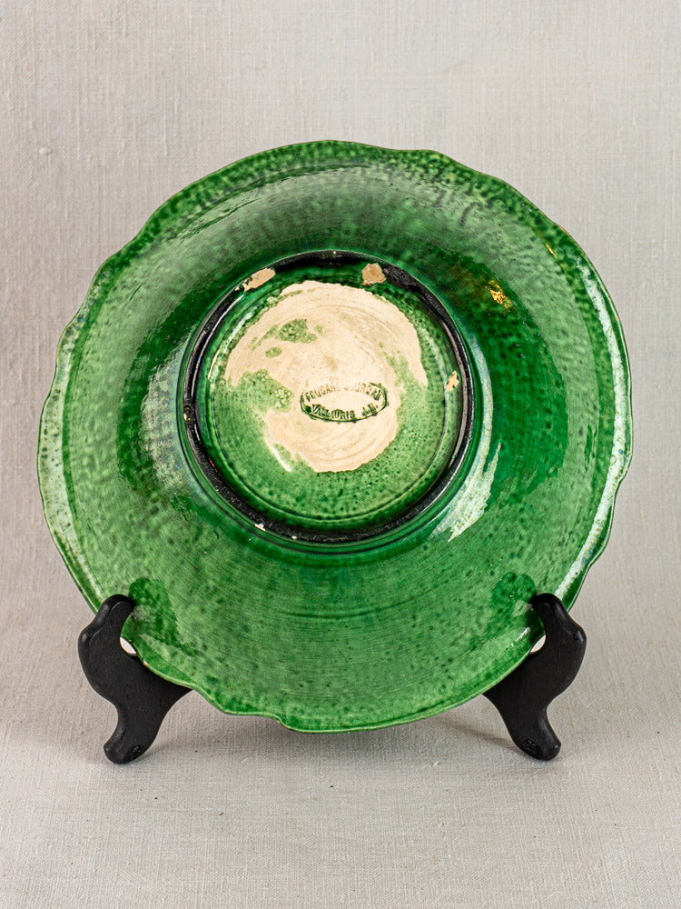 French Vallauris ceramic bowl by Foucard-Jourdan, green glazed with scalloped edge, worn beige center, on black stand.