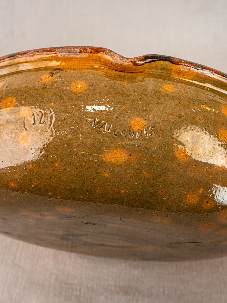 Base of antique French Vallauris Jaspé terracotta poêlon with stamped marking and mottled glaze.