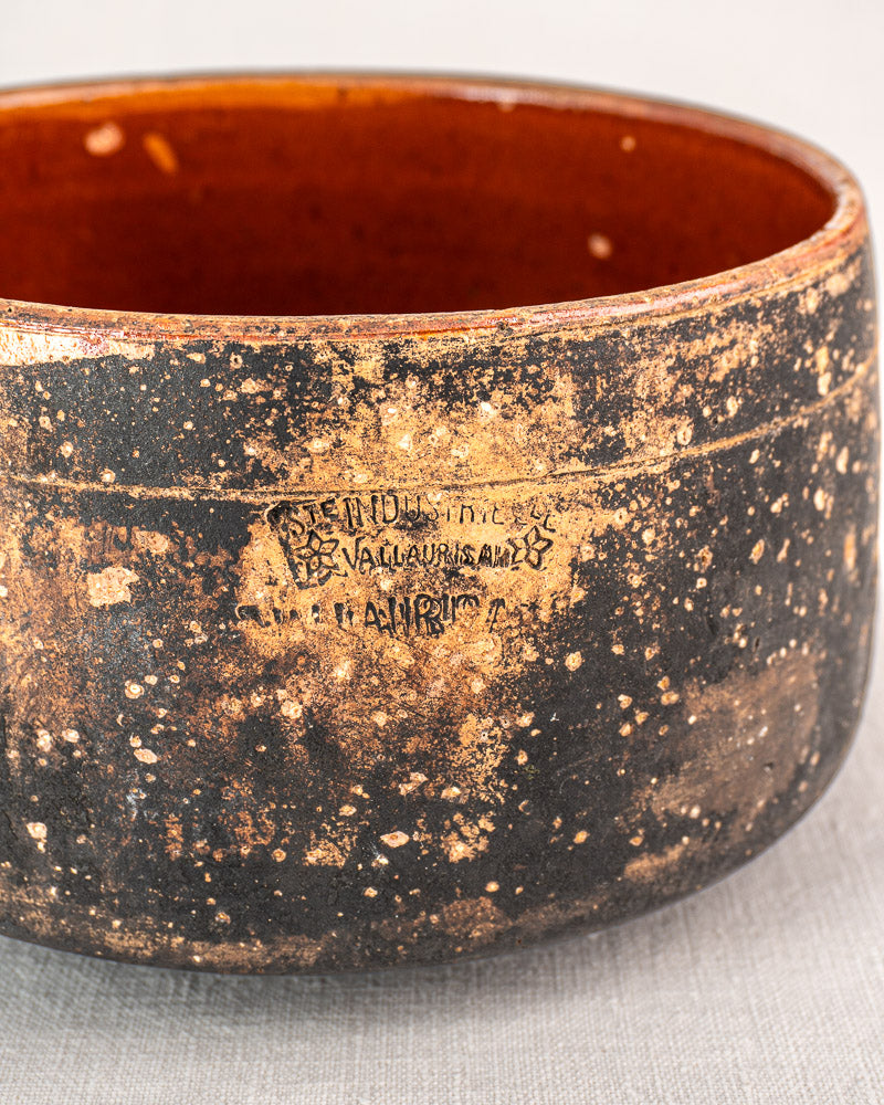 Vintage French Vallauris glazed terracotta cooking pot with mottled gold-speckled exterior and engraved label, reddish-brown interior.
