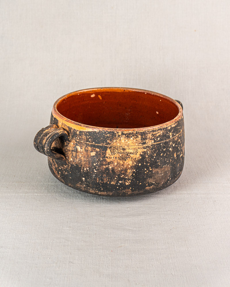 Early 20th-century French Vallauris terracotta pot with rustic round shape, side handle, and orange-brown glazed interior.