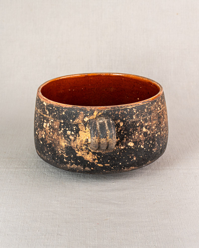 French Vallauris glazed terracotta cooking pot, dark speckled exterior, rich brown interior, textured grip, Provençal style.