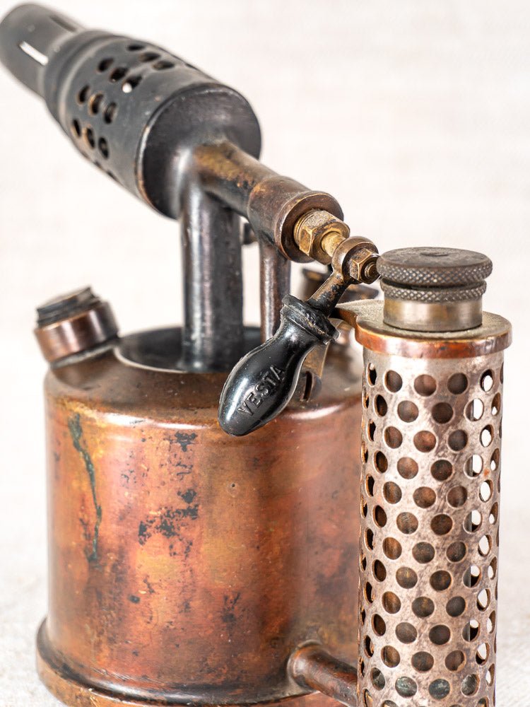 Vintage French blowtorch by Vesta F.J. Paris, circa 1920, with perforated handle and aged copper body.