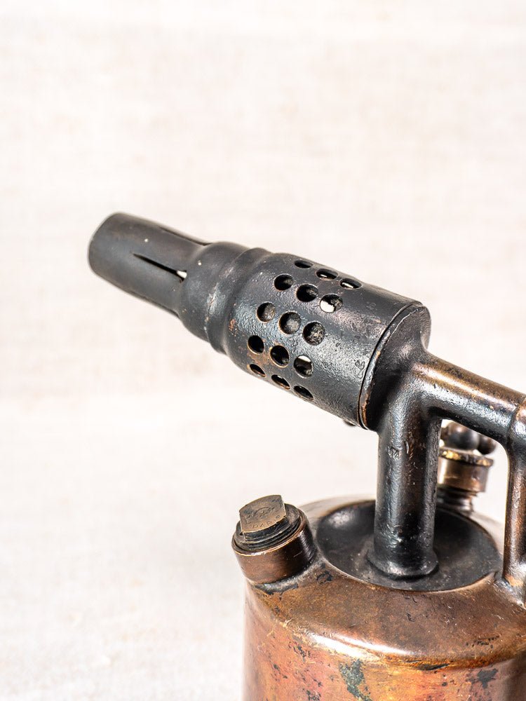 Vintage French Vesta F.J. Paris blowtorch, circa 1920, with perforated nozzle and visible tarnish against light background.
